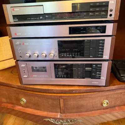 Sale Photo Thumbnail #163: Vintage Kyocera stereo stack featuring brushed aluminum faceplates and wood side panels, including a CD player, tuner/amplifier, and cassette deck.