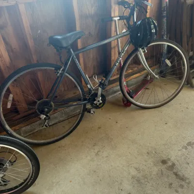 Sale Photo Thumbnail #214: Trek Multitrack 700 hybrid bicycle in dark gray, complete with a black helmet hanging from the handlebars.