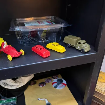 Sale Photo Thumbnail #150: Collection of vintage molded plastic toy vehicles, including a red race car, red sedan, yellow sedan, and olive green military truck.