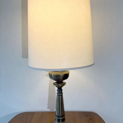 Mid-century traditional brass table lamp with a fluted column base and a tall linen drum shade.