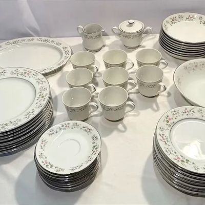 Large vintage fine china dinnerware service featuring a delicate floral rim pattern and silver accents, including plates, teacups,...
