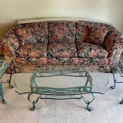 Floral patterned three-cushion sofa paired with a set of three metal and glass tables and matching table lamps.