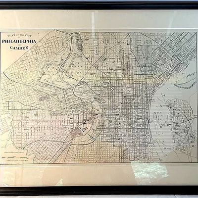 Framed antique map titled 'Plan of the City of Philadelphia and Camden', featuring detailed street grids and waterways in a...