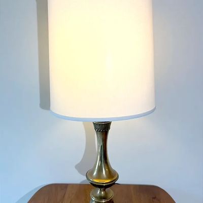 Mid-century traditional brass table lamp with a tall white cylindrical drum shade.