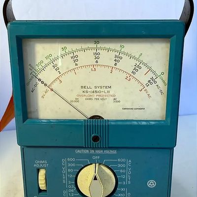 Vintage Bell System KS-14510-L11 analog multimeter in a teal casing with a black leather carrying strap.