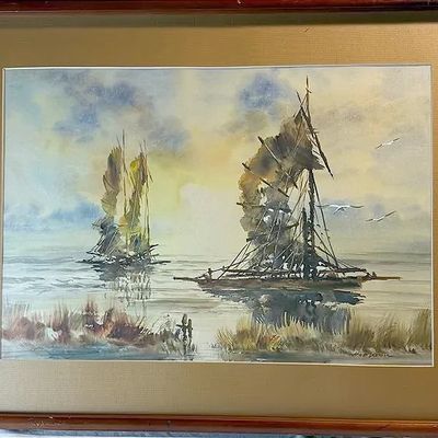 Framed maritime watercolor painting depicting sailboats on calm water at sunset, presented in a beige mat and wooden frame.