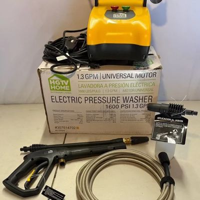 HGTV Home yellow electric pressure washer set, 1600 PSI 1.3 GPM, with spray gun, hose, soap applicator, and original box.