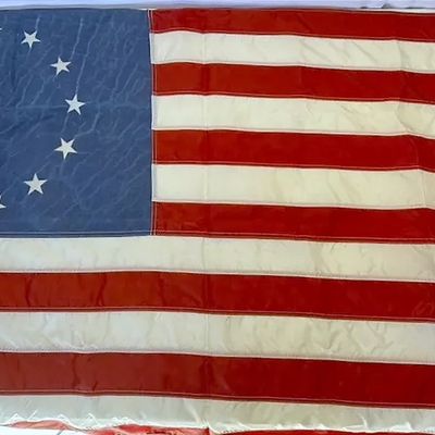 Vintage Betsy Ross style 13-star American flag, featuring a circular pattern of white stars on a blue canton, sewn stripes, and brass...