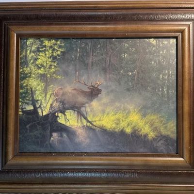 Framed wildlife print depicting a bull elk in a misty forest clearing, housed in a wide, ornate dark wood frame.