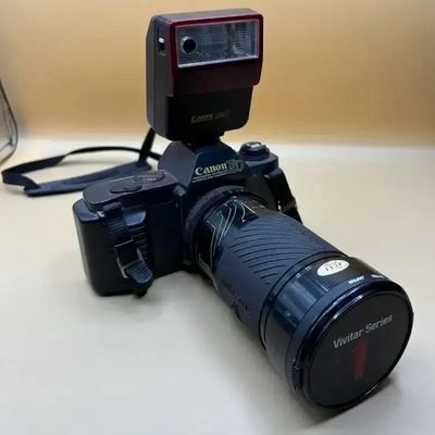 Vintage Canon T50 35mm SLR film camera fitted with a Vivitar Series 1 zoom lens, Canon Speedlite 244T flash, and neck strap.
