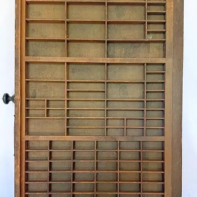 Vintage wooden printer's tray drawer featuring various sized compartments and an original side knob.