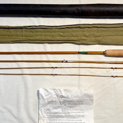 Vintage split-bamboo fly fishing rod set complete with cork grip, fabric sleeve, protective travel tube, and informational paperwork.