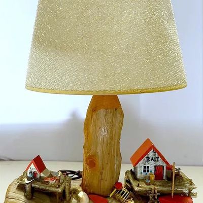 Vintage novelty table lamp featuring a rustic driftwood base with miniature bait shop dioramas and a textured fabric shade.