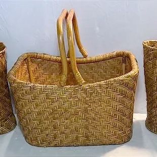 Set of three vintage woven rattan tote bags with sturdy handles.
