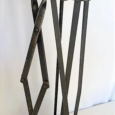 Vintage wrought iron fireplace tool set featuring loop handles, including a poker, tongs, shovel, brush, and matching stand.