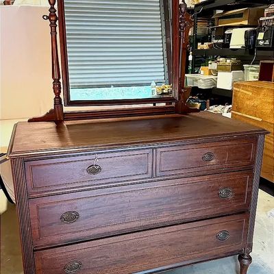 Antique dark mahogany dresser featuring four drawers with ornate hardware and a matching attached swivel mirror with turned side posts.