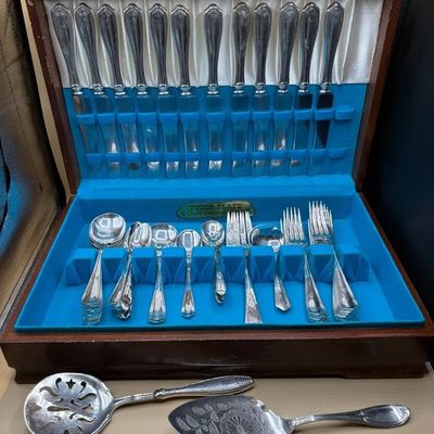Vintage Tudor Plate by Oneida Community silver-plated flatware set housed in a wooden felt-lined chest, accompanied by two serving utensils.