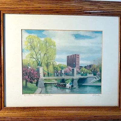 Framed artwork depicting the Boston Public Garden swan boats, titled and signed on the mat, set in a solid wood oak frame.