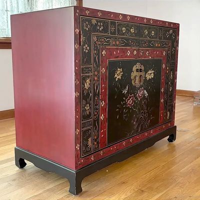Chinese-style lacquered storage cabinet featuring hand-painted floral motifs on a black and red finish with brass hardware.