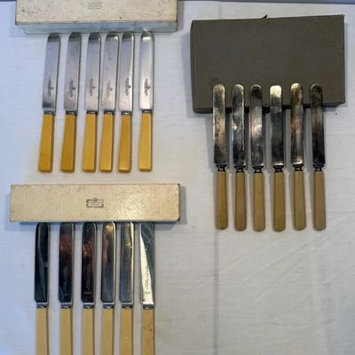 Three sets of vintage English fruit or dinner knives with Bakelite or faux bone handles, complete with original presentation boxes.