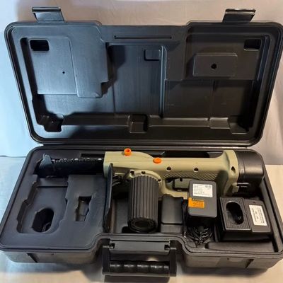 Handheld cordless mini chainsaw set in a black plastic hard-shell carrying case, complete with battery, charger, and power adapter.