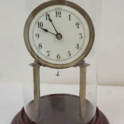 Sale Photo Thumbnail #138: 1138	ANTIQUE ANNIVERSARY CLOCK MARKED URANIA UNDER GLASS DOME, NO PENDULUM, APPROXIMATELY 14 IN HIGH																																																																																																																																																											