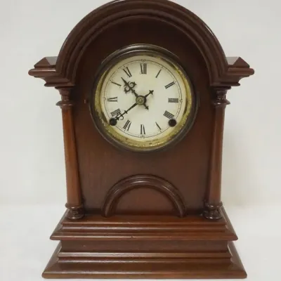 Sale Photo Thumbnail #133: 1133	WATERBURY WALNUT SHELF CLOCK W/REMOVABLE HALF MOON WOOD DOOR IN FRONT, APPROXIMATELY 1 IN X 5 IN X 14 IN HIGH																																																																																																																																													