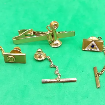 Collection of vintage gold-tone telephone-themed men's accessories, including a candlestick phone tie clip, a Bell System tie tack,...
