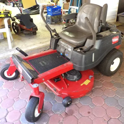 Toro TimeCutter MX 4260 zero-turn riding lawn mower featuring dual steering levers, a high-back seat with armrests, and a red deck with...