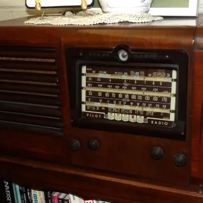 Vintage Pilot Radio wooden tabletop receiver featuring a multi-band tuning dial and slatted speaker grille, circa late 1930s or 1940s.