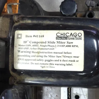 Detail view of a Chicago Electric Power Tools 10-inch compound slide miter saw, item #41168, displaying the specification and safety...