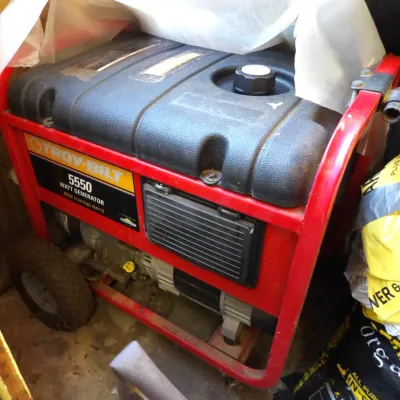 Troy-Bilt 5550 watt portable generator featuring a red steel roll frame and wheels.
