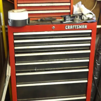 Craftsman red steel rolling tool chest combo, featuring a multi-drawer base cabinet on casters topped with a matching Craftsman...