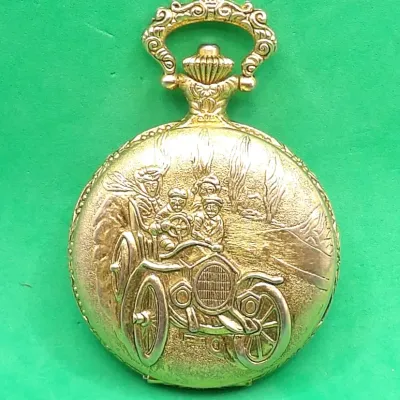 Vintage gold-tone pocket watch featuring a detailed embossed relief of an early 20th-century antique automobile with passengers on the...