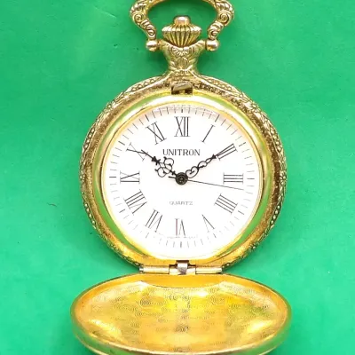 Vintage Unitron gold-tone quartz pocket watch featuring an ornate hunter case, detailed crown, white dial with Roman numerals, and...