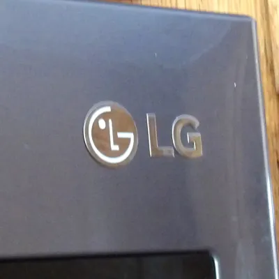 Close-up of an LG brand household appliance in a dark grey finish.
