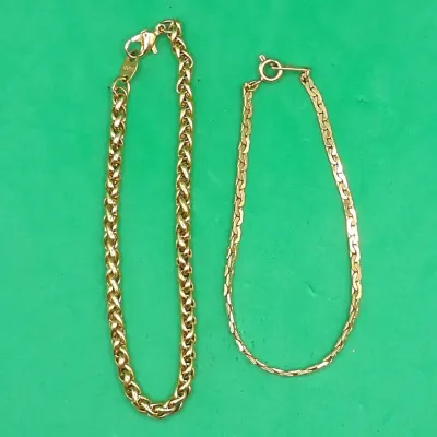 Two gold-tone chain bracelets, including a thicker woven wheat-style chain with a lobster clasp stamped 1/20 12K and a thinner flat...