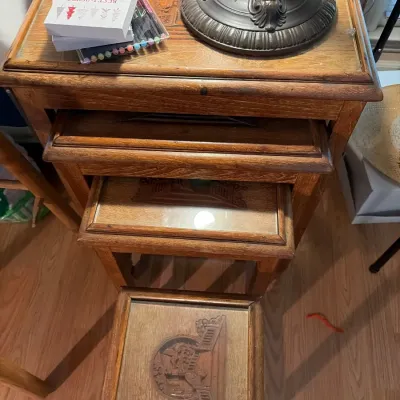 Set of vintage carved wood nesting tables featuring inset glass tops with carved Asian motif relief details.