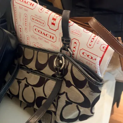 Sale Photo Thumbnail #244: Coach brown signature C canvas shoulder bag shown with Coach branded tissue paper and other purses.
