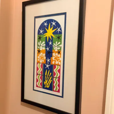 Framed Henri Matisse cut-out print featuring a colorful stained-glass window design, presented in a black frame with a white double mat.