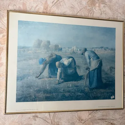 Framed print reproduction of Jean-François Millet's "The Gleaners" set in a simple thin gold-tone metal frame.