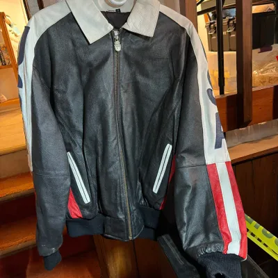 Vintage black, white, and red leather bomber jacket with graphic sleeve details and a white fold-over collar.