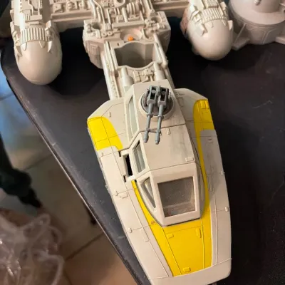 Sale Photo Thumbnail #110: Vintage Kenner Star Wars Y-wing fighter vehicle toy, featuring yellow paint details, dual laser cannons, and cockpit glass.