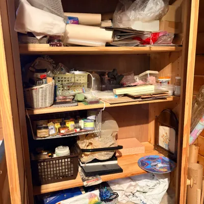 Sale Photo Thumbnail #149: Tall pine armoire cabinet filled with various art supplies, craft items, and household storage contents.