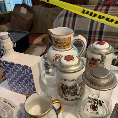 Collection of vintage beer steins, decanters, and ceramic drinkware, including a Stroh's lidded stein, a Dinkelacker glass stein,...