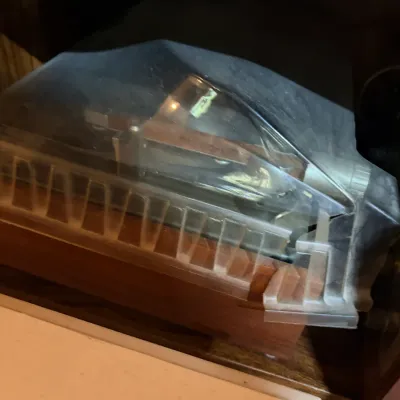 Sale Photo Thumbnail #201: Vintage stereo turntable component housed inside a wooden cabinet with a clear dust cover.