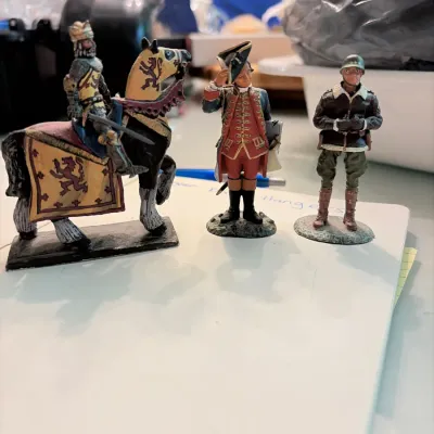 Sale Photo Thumbnail #124: Trio of hand-painted lead or metal military toy figures, including a mounted medieval knight, an 18th-century officer, and a WWII General Patton figure.