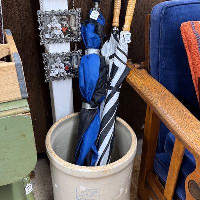 Sale Photo Thumbnail #8: Large vintage stoneware crock used as an umbrella stand, holding several long umbrellas next to a hanging triple picture frame.