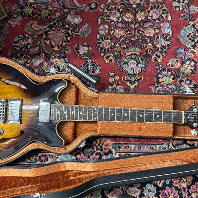 Vintage Ibanez Artist series semi-hollow body electric guitar with sunburst finish, resting inside its original plush-lined hard case.