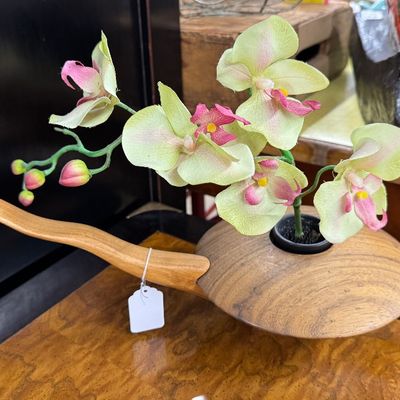 Sale Photo Thumbnail #31: Hand-turned wooden pipe-shaped vessel featuring a contoured handle and an artificial green and pink orchid stem.